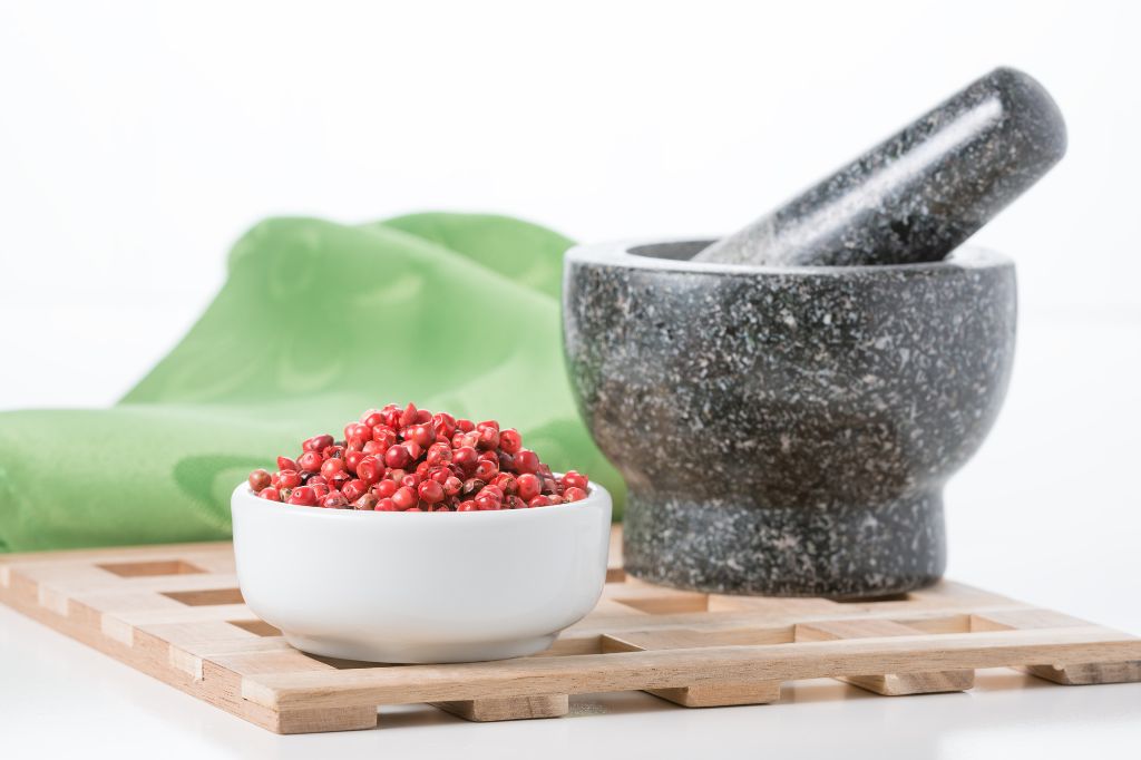 peppercorn in a bowl with a mortar and pestle in the background